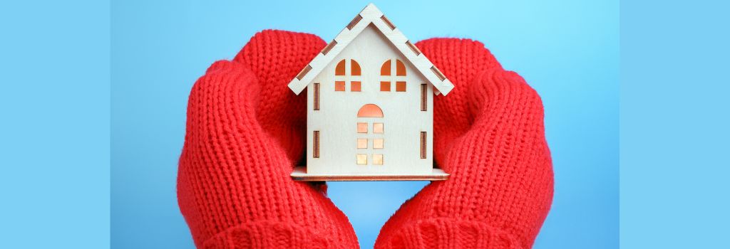 Photo of hands with red gloves on holding a miniature ouse