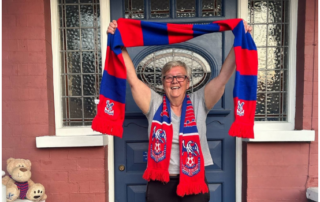 Photo of Debbie Bentley-Ross holding a CPFC scarf