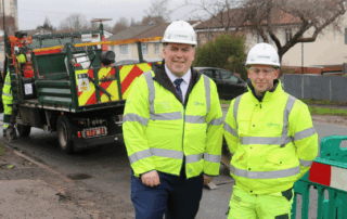 Mayor Perry stands next to a member of the highways team as they work to repair potholes in New Addington.