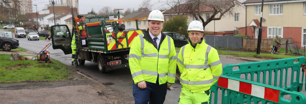 Mayor Perry stands next to a member of the highways team as they work to repair potholes in New Addington.